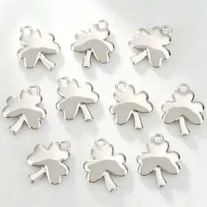 Detail view of polished silver clover charms, showing glossy smooth finish and neat hanging loops.