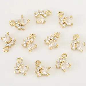 Close-up of gold-plated pet paw charms with sparkling cubic zirconia, perfect for DIY jewelry.