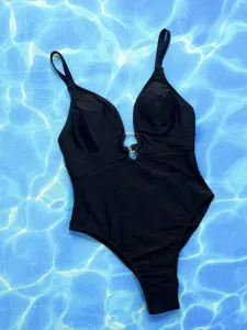 Black one-piece swimsuit featuring a chic front golden ring detail and deep V-neck cut.