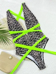 Sexy leopard print one-piece swimsuit with neon green criss-cross straps for beach vacation.
