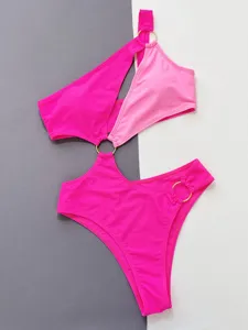 Pink one-piece cutout swimsuit with gold rings, stylish contrast color flat lay product detail.