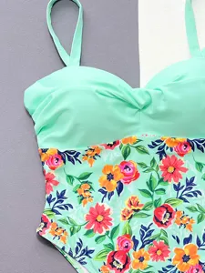 Mint green one-piece swimsuit detail, featuring vibrant floral print and elegant twist bustier.