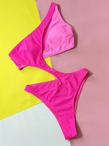 Close-up view of hot pink cut-out swimwear showcasing smooth fabric texture and details.
