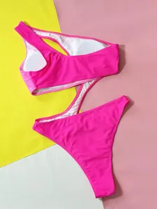 Detail view of hot pink one-piece monokini swimsuit featuring a chic cutout design and strap.