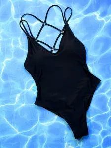 Detailed view of a black one-piece swimsuit with stylish multi-straps and metallic rings.