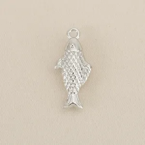 Silver-tone metal fish pendant detail, textured scale design and loop for DIY crafts.