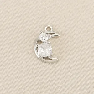 Silver tone copper crescent moon pendant with sparkling cubic zirconia stones for DIY jewelry making.
