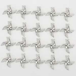 Detailed view of silver-plated four-leaf pinwheel pendant charms paved with sparkling cubic zirconia.