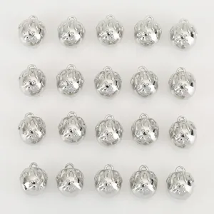 Close-up detail of shiny silver metal craft bells with paw print design for DIY jewelry.