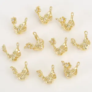 Close-up of gold-plated bow and flower rhinestone charms, detailed DIY jewelry accessory.