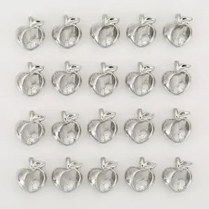Silver tone apple pendant detail shot, hollow charm with sparkling zirconia stone.