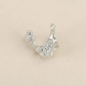 Silver tone metal DIY charm pendant featuring a 3d bow and cubic zirconia flower detail.