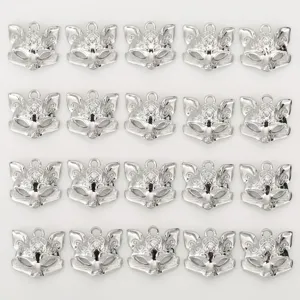 Close-up of shiny silver fox mask charms, delicate hollow-out pendant details for DIY jewelry.