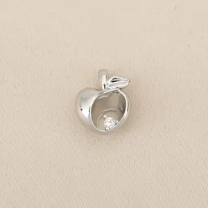 Close-up detail of silver-tone hollow apple pendant with sparkling cubic zirconia charm.