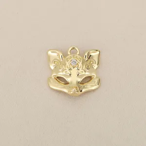 Close-up of cute fox mask pendant detail, glossy gold plated metal DIY jewelry accessory.