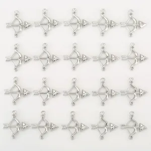 Detailed view of silver bow and arrow charm pendants with cubic zirconia for DIY jewelry making.