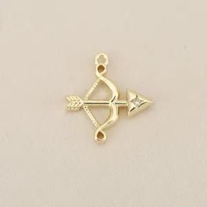 Close-up detail of a gold-plated bow and arrow charm with sparkling zircon for DIY jewelry.
