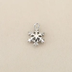 Close up view of the silver tone snowflake charm pendant showing intricate details and loop.