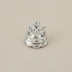 Detailed view of silver crown charm, showing layered metal waves for DIY jewelry.