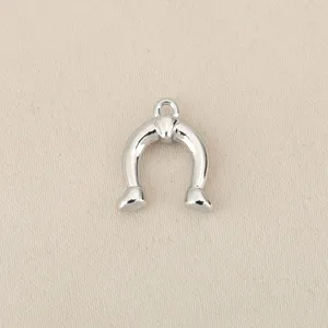 Silver horseshoe pendant detail, metal DIY jewelry charm accessory, close-up view.