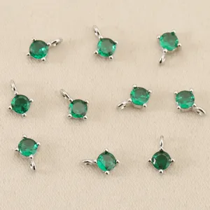 Close-up van ronde groene zirkonhangers met dubbele lussen voor DIY-sieraden maken.