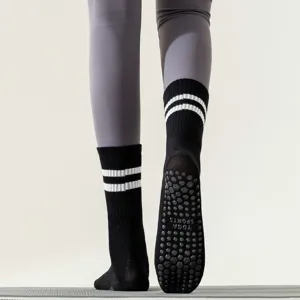 Detailed close-up view of black anti-slip yoga socks featuring white stripes and grip sole.