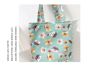 Close up of light green canvas tote bag featuring cute cartoon Shiba Inu dogs pattern.