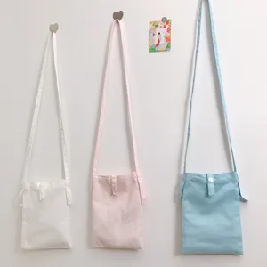 Einfaches Leinen Umhängetasche Detail, bunte lässige Mini Handytasche am Haken hängend.
