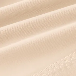 Detailed view of smooth nude bra fabric, showing fine texture and clean stitching.