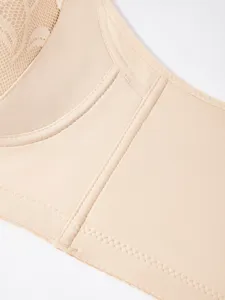 Detailed view of beige women's lace bra, showcasing delicate fabric and fine stitching quality.