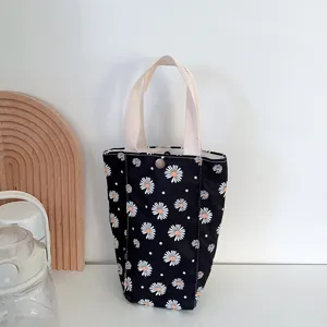 Sac cabas en toile noire avec motif marguerite blanche et pochette tasse portable.