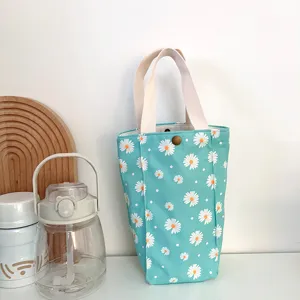 Vue rapprochée du sac cabas en toile turquoise à motif marguerite avec une texture solide.