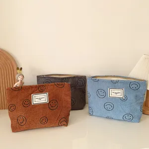 Detailansicht der Kord Kosmetiktasche mit weicher Textur, niedlichem Smiley und Reißverschluss.