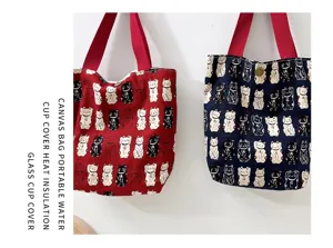 Canvas portable bento bag detail featuring cute lucky cat pattern and durable red handles.