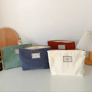 Corduroy cosmetic bag detail showing solid color portable zipper travel pouch organizer.