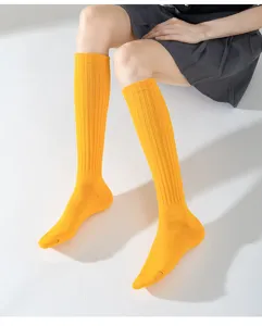 Detailaufnahme von leuchtend gelben Kniestrümpfen mit Rippstrickmuster für den modischen Alltag.