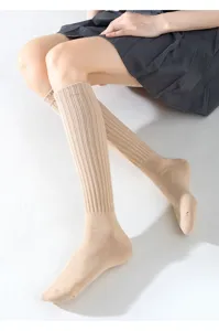 Nahaufnahme von beige gerippten Slouch-Socken an einem Modell mit weicher Textur und Passform.