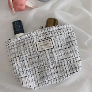 Elegant tweed makeup bag for women, stylish portable cosmetic pouch with large capacity storage.