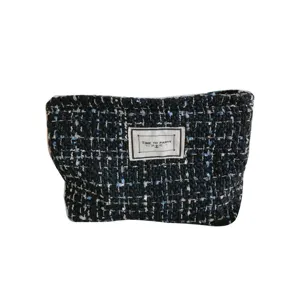 Elegant tweed cosmetic bag for women, stylish black and white woven travel makeup pouch.