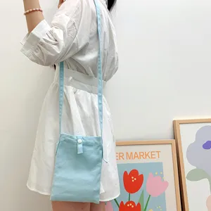 Detaillierte Nahaufnahme einer hellblauen Canvas Umhängetasche für Handys im Alltaggebrauch.