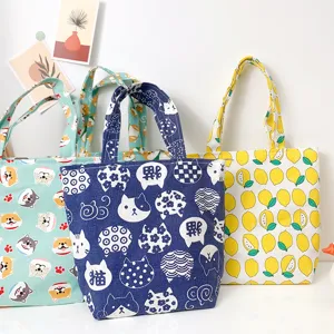 Canvas lunch bag detail showcasing cute cartoon cat, dog and lemon printed patterns for daily use.