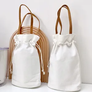 Dettaglio della borsa in tela con chiusura a cordoncino e manici marroni, stile semplice.