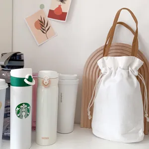 Borsa shopper in tela bianca minimalista con manici marroni, custodia con coulisse.