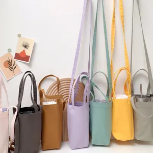 Detailansicht der Leinen-Bechertasche mit mehrfarbigem Stoff, Umhängegurt und sauberer Naht.