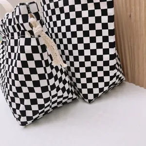 Bolso bento de lona a cuadros blancos y negros con un práctico cierre de cordón.