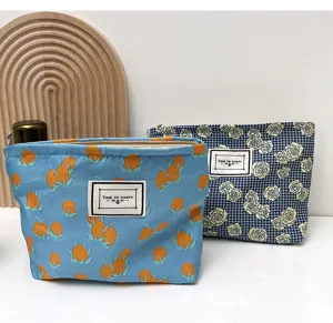 Detail view of canvas cosmetic makeup bags featuring floral prints and woven label accents.