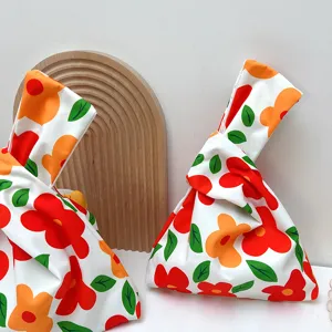 Close-up detail of Japanese style floral knotted wrist bag canvas cute floral handbag portable.