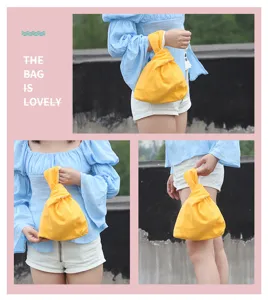 Detail view of the retro Japanese style yellow knot wrist bag, showcasing fabric texture.