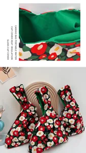 Close-up shot of Japanese canvas knot wrist bag with floral pattern and green lining.