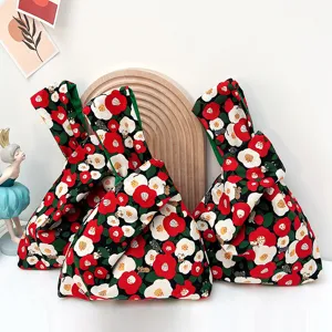 Floral knot wrist bag detail showing Japanese style camellia print and convenient loop handle.